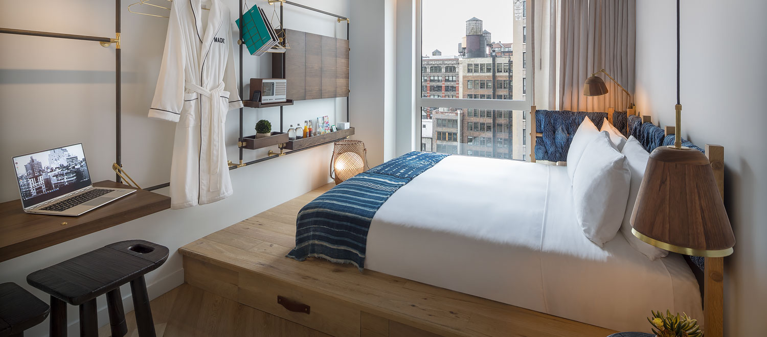 Desk with laptop, bathrob, and bed